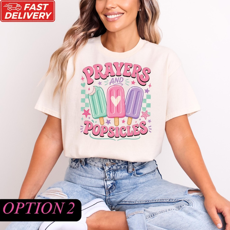 A woman wearing a white t-shirt with a graphic design of three popsicles and the text "Prayers and Popsicles" printed on it.