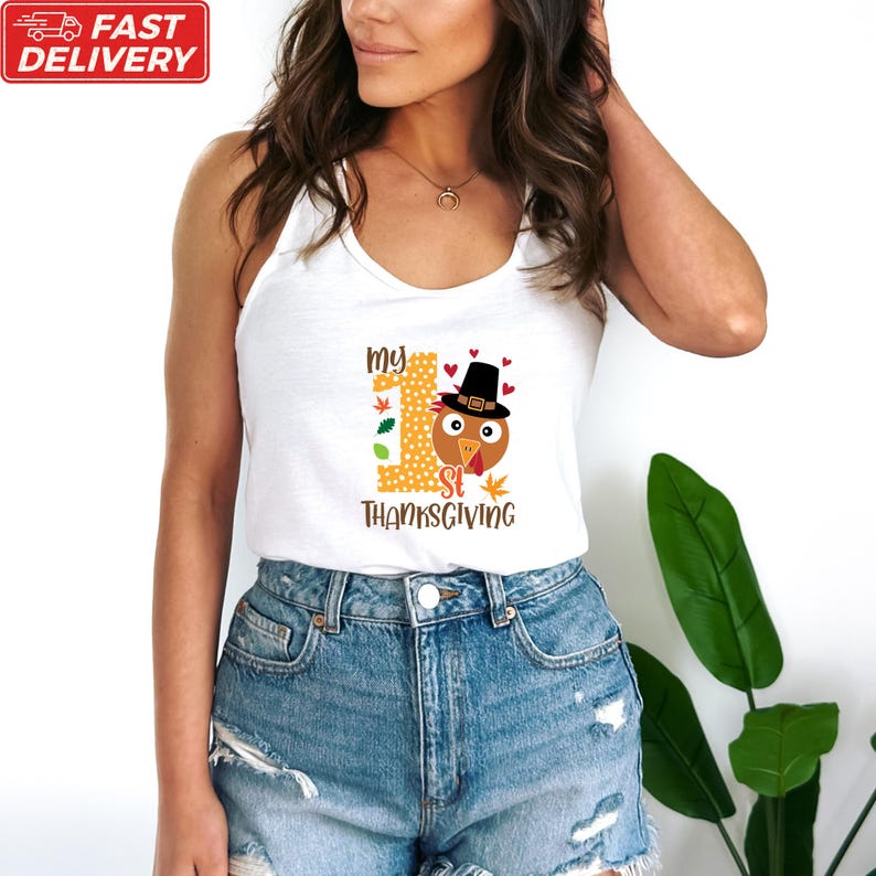A woman wearing a white tank top with a graphic of a turkey and the text "My 1st Thanksgiving" printed on it.