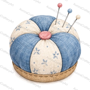 Op de afbeelding: Een rond stoffen speldenkussen met afwisselende segmenten van blauwe textuurstof en crèmekleurige stof met een klein blauw bloemenpatroon. Een roze knoop zit in het midden en er zijn drie spelden met roze, blauwe en crèmekleurige koppen ingestoken.