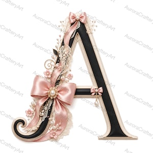 May include: A decorative letter A featuring a black center with a cream-colored border. The letter is adorned with pink satin ribbons, lace trim, small pink fabric flowers, and faux pearl accents. A small bow with a dangling pearl charm is attached.