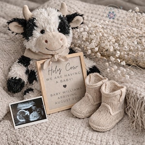 以下が含まれることがあります： 白と黒のぬいぐるみの子牛と、「Holy Cow, We Are Having a Baby!」と書かれた額入りの告知、赤ちゃんのスキャン、ニットのベビーブーツ。 告知には赤ちゃんの名前と予定日が記載されています。