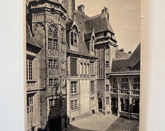 May include: Black and white vintage travel poster of Bourges, France, featuring the Hotel de Jacques Coeur. The poster is held by two binder clips and displays the word "FRANCE" in large, bold letters.