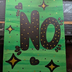 May include: A rectangular canvas painting featuring a green gradient background with horizontal brushstrokes. The word NO is painted in large black letters with gold polka dots. The design includes black and gold star shapes and small black hearts.