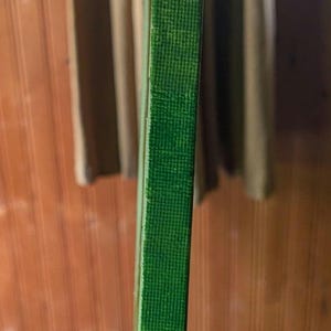 May include: A rectangular canvas panel with a textured surface painted in a solid, vibrant green colour. The side edges of the canvas are also painted in the same green hue, showing a visible woven fabric texture across the entire surface area.