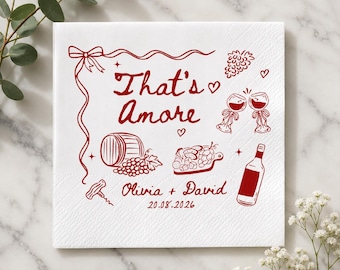 May include: A square white paper napkin featuring dark red line art illustrations including a wine barrel, grapes, a charcuterie board, wine glasses, and a bottle. The text reads That's Amore, Olivia + David, and the date 20.08.2026.