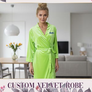 May include: A vibrant lime green velvet robe with a wrap design and a matching belt. The robe features long sleeves and is embroidered with a name in blue. The text "CUSTOM VELVET ROBE" is displayed at the bottom of the image.