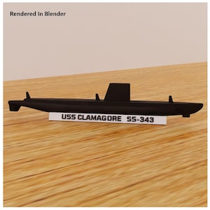May include: A black model submarine with the text "USS CLAMAGORE SS-343" on a white label. The model has a rectangular fin and several small protrusions. The image is labeled "Rendered In Blender".