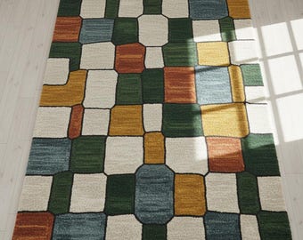 May include: A rectangular area rug with a geometric pattern. The rug features a patchwork design with squares and rectangles in shades of green, blue, yellow, orange, and cream, outlined in black. The rug is made of a soft, textured material.
