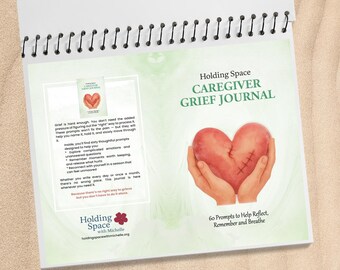 May include: A spiral-bound journal titled "Holding Space Caregiver Grief Journal." The cover features a heart held in hands, with text indicating 60 prompts to help reflect, remember, and breathe. The journal's pages include text about processing grief.