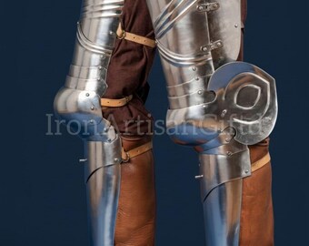 May include: Polished steel leg armor, including greaves and knee cops, over brown leather boots and breeches. The armor is riveted and articulated, with leather straps. The image is set against a dark blue background.