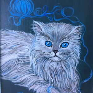 Op de afbeelding: Een witte, pluche kat met blauwe ogen zit op een donkerblauwe achtergrond. De kat speelt met een blauwe bol wol. Het schilderij is gesigneerd met "Patsy A. Dorsett '85".