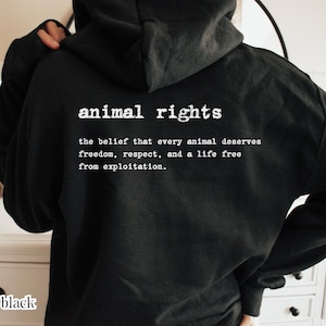 Può includere: Una felpa nera con cappuccio che presenta una scritta bianca sul retro: animal rights, the belief that every animal deserves freedom, respect, and a life free from exploitation. Il capo è dotato di maniche lunghe e cappuccio.