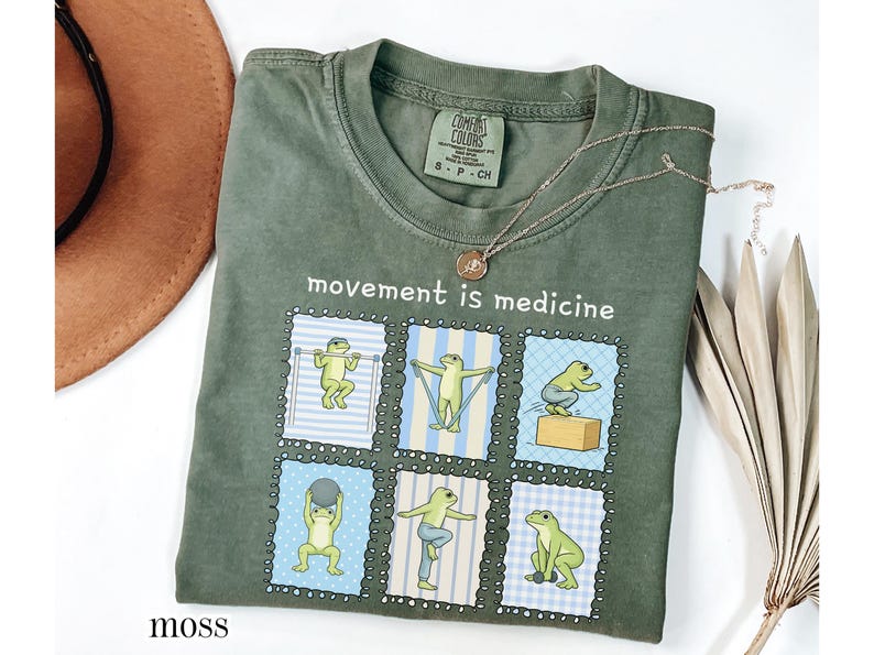 green frogs doing therapy exercises on a Comfort Colors® t-shirt with “movement is medicine” text with stamps design, printed on soft cotton shirt in various earthy tones
