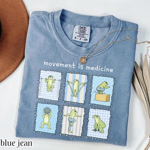 green frogs doing therapy exercises on a Comfort Colors® t-shirt with “movement is medicine” text with stamps design, printed on soft cotton shirt in various earthy tones