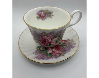 Può includere: Servizio da tè bianco con tazza e piattino decorati con rose rosa e fiori viola. I bordi sono rifiniti in oro. La tazza ha un manico curvo. Ideale per il tè.