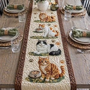 May include: A quilted table runner featuring detailed cat designs. The runner showcases four different cat illustrations, each on a green oval, with paw prints scattered around. The cats are in various poses, and some have food bowls. The border is a dark brown.