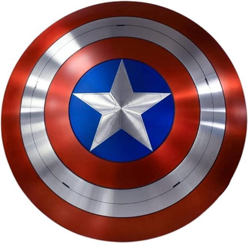 May include: A round shield with a red outer ring, a silver middle ring, and a blue center. A large, five-pointed silver star is centered on the blue circle. The shield has a metallic appearance.
