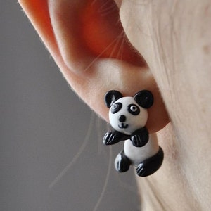 May include: A pair of black and white panda bear earrings. The earrings are made of polymer clay and are about 1 inch in size.