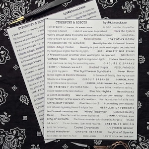 May include: A black and white bandana with a paisley pattern serves as a backdrop for two printed cards with cyberpunk-themed text and a pair of scissors. A pair of tweezers is also present.