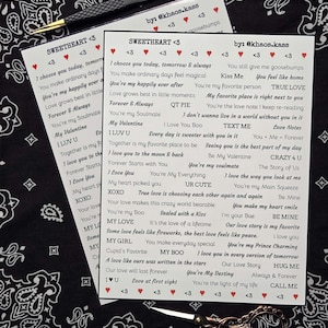 Puede incluir: Dos hojas de papel con frases románticas como "Sweetheart <3" e "I love you" se muestran. Un par de tijeras y unas pinzas también son visibles en una superficie con estampado en blanco y negro.