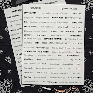 May include: Two sheets of Halloween-themed stickers with various phrases like "Happy Halloween" and "Trick or Treat." A pair of tweezers and decorative scissors are also in the image. The background is a black and white paisley bandana.