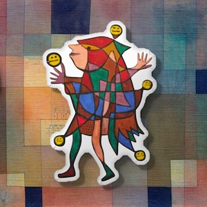 May include: A colorful, abstract art pillow featuring a figure juggling yellow smiley faces. The figure is depicted in a patchwork of red, green, blue, and brown, with a whimsical, cartoonish style. The background is a mosaic of muted colors.