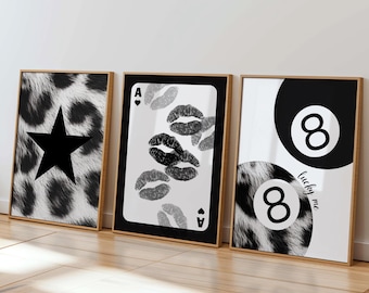 May include: Three framed art prints. The first features a black star on a black and white animal print background. The second is a playing card with lip prints. The third shows a black 8-ball with the text "lucky me".