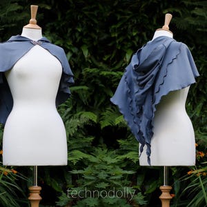 May include: A blue hooded cape with a scalloped edge. The cape is draped over a white mannequin.