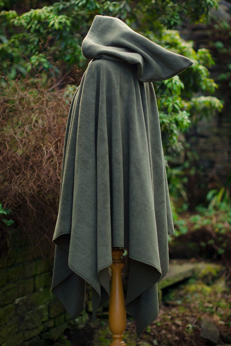 May include: A hooded cloak in a dark green color. The cloak is made of a soft, plush fabric and has a simple, elegant design.