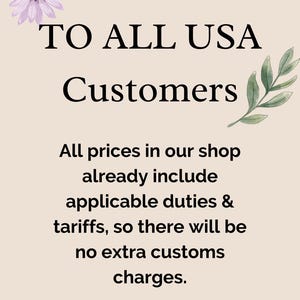 Könnte beinhalten: Beigefarbener Hintergrund mit schwarzem Text: „AN ALLE USA-Kunden“. Der Text erklärt, dass die Preise Zölle und Steuern beinhalten, ohne zusätzliche Zollgebühren. Blumen- und Blätterakzente schmücken das Bild.