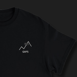 Könnte beinhalten: Schwarzes T-Shirt mit einer kleinen weißen Grafik auf der Brust. Die Grafik zeigt ein stilisiertes Liniendiagramm mit dem Wort "GAPS" darunter. Das T-Shirt hat kurze Ärmel und einen Rundhalsausschnitt.