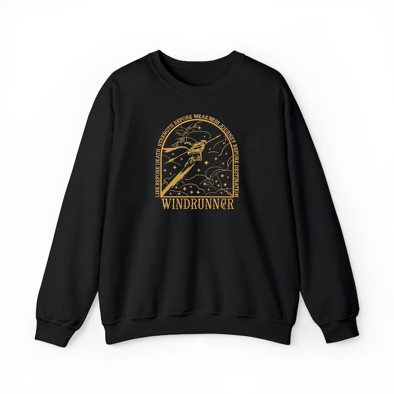 May include: Black sweatshirt with a gold graphic featuring a stylized figure, stars, and the text "WINDRUNNER." The design is framed by the words "LIFE BEFORE DEATH, STRENGTH BEFORE WEAKNESS, JOURNEY BEFORE DESTINATION."