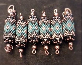 May include: Six beaded cylindrical pendants. Each pendant features a pattern of turquoise, black, and copper-colored beads. The pendants have a loop at the top for hanging and a small bead at the bottom. The background is a dark, solid color.