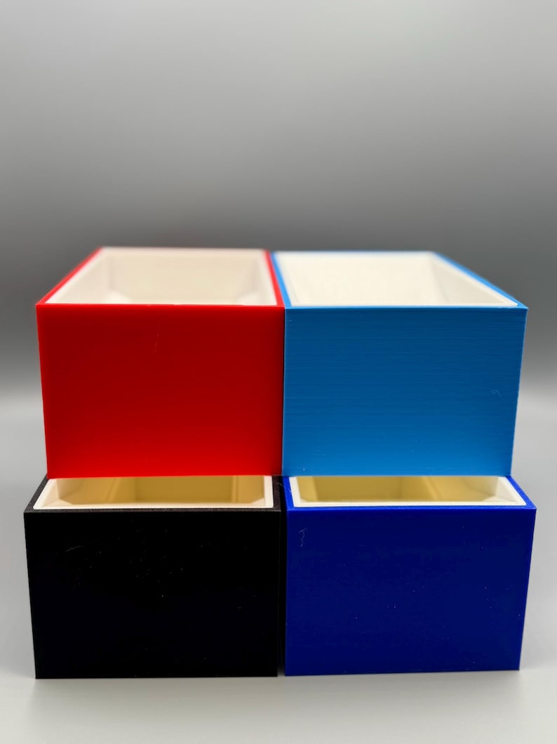 May include: Four small rectangular boxes stacked in two rows. The top row has a red box on the left and a blue box on the right. The bottom row has a black box on the left and a dark blue box on the right.
