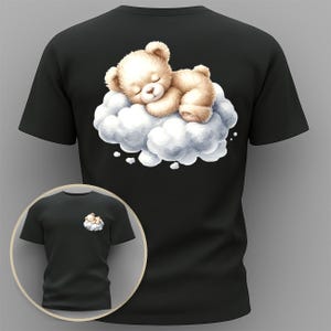 May include: Black t-shirt featuring a sleeping teddy bear on a cloud. The bear is light brown with a cream-colored belly and paws. The cloud is white and gray. A smaller version of the design is on the front of the shirt.