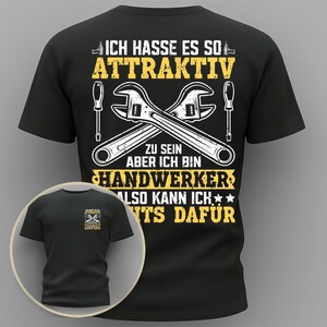 May include: Black t-shirt with a humorous graphic in yellow and white. The design features crossed wrenches, screwdrivers, and text that reads "ICH HASSE ES SO ATTRAKTIV ZU SEIN ABER ICH BIN HANDWERKER ALSO KANN ICH NTS DAFÜR."