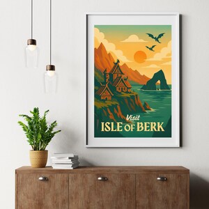 May include: A framed art print featuring a vintage travel poster design. The poster depicts a coastal landscape with mountains, a village, and the text "Visit Isle of Berk". The color palette includes orange, green, and blue.
