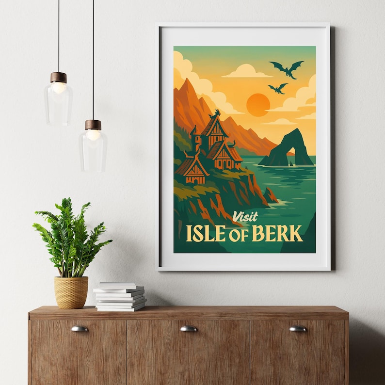 May include: A framed art print featuring a vintage travel poster design. The poster depicts a coastal landscape with mountains, a village, and the text "Visit Isle of Berk". The color palette includes orange, green, and blue.