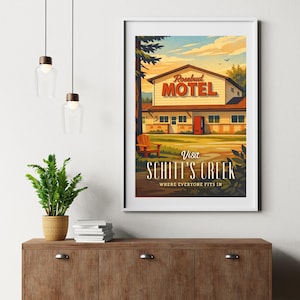 May include: Framed art print featuring a vintage-style illustration of the Rosebud Motel from Schitt's Creek. The artwork showcases the motel's exterior with the text "Visit Schitt's Creek" and "Where Everyone Fits In."
