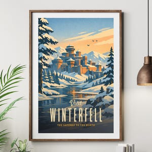 Könnte beinhalten: Ein gerahmtes Reiseplakat mit einer verschneiten Berglandschaft und einer großen Steinburg in der Mitte. Der Text lautet Visit WINTERFELL THE GATEWAY TO THE NORTH. Die Szene zeigt Kiefern, einen Fluss sowie einen orangefarbenen und blauen Himmel.