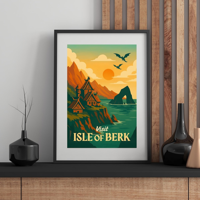 May include: Framed art print featuring a stylized landscape with Viking-style houses on a cliff overlooking the sea. The image has a warm color palette with orange, green, and blue hues. The text "Visit Isle of Berk" is at the bottom.