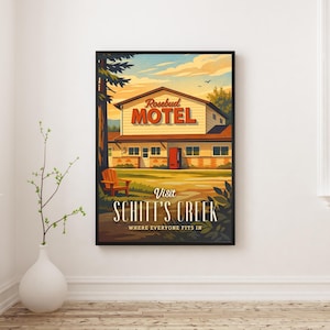 May include: Framed art print featuring a vintage-style illustration of the Rosebud Motel from Schitt's Creek. The artwork showcases the motel's exterior, a wooden chair, and the text "Visit Schitt's Creek, Where Everyone Fits In."