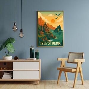 May include: A framed poster with a vintage travel theme. The artwork depicts a coastal landscape with mountains, buildings, and the text "Visit Isle of Berk." The color palette includes orange, green, and blue tones, with two flying creatures in the sky.