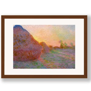 Può includere: Stampa incorniciata di un dipinto di paesaggio con due grandi covoni di fieno in un campo. L'opera d'arte utilizza una tavolozza di colori caldi, tra cui rosa, arancione e giallo, per raffigurare un tramonto. Il dipinto è in una cornice marrone.