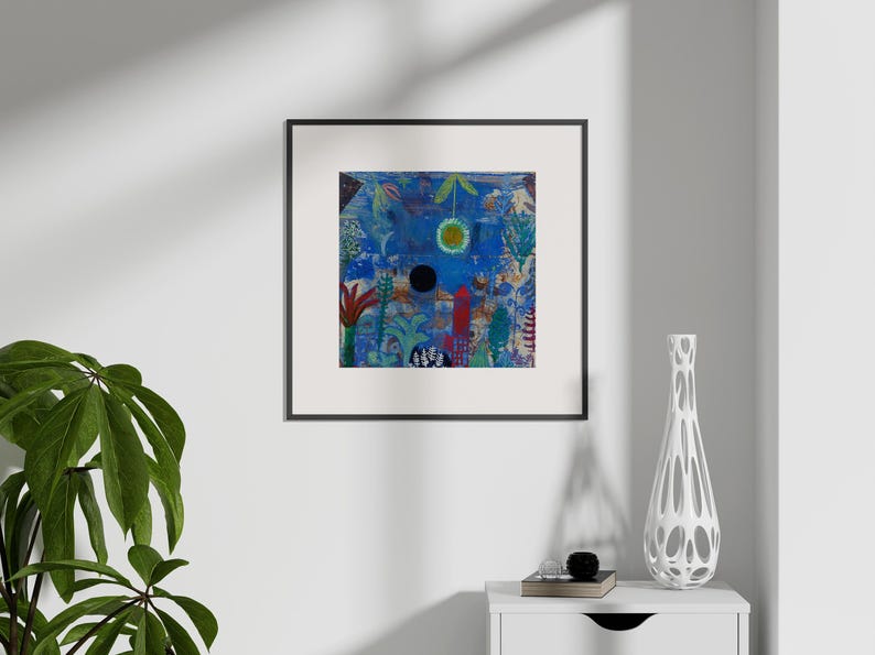 May include: Abstract art print in a black frame. The artwork features a blue background with colourful shapes, a black circle, and a yellow sun. A white vase with a unique design sits on a white table.