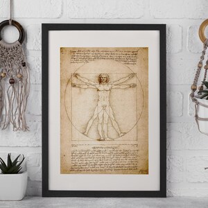 May include: Framed print of Leonardo da Vinci's Vitruvian Man, a study of human proportions. The artwork features a male figure within a circle and square, with detailed sketches and text. The print is in a black frame.