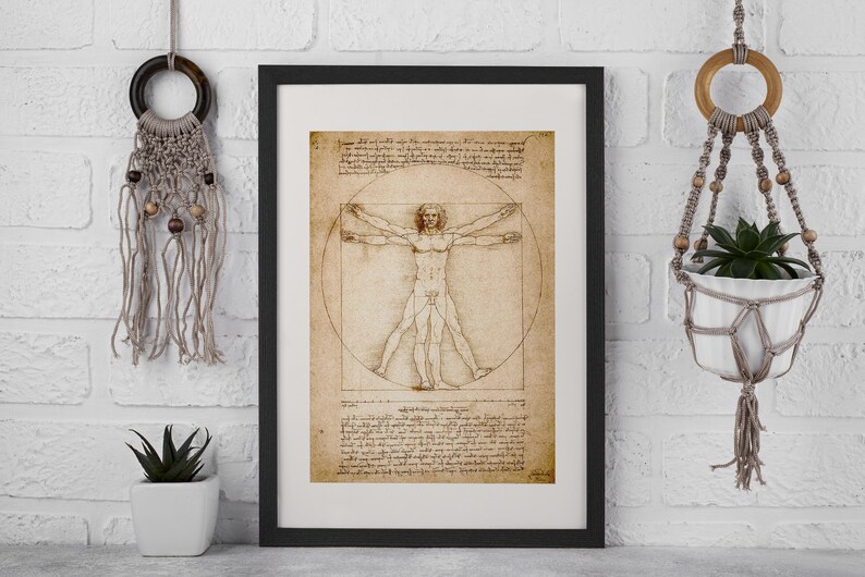 May include: Framed print of Leonardo da Vinci's Vitruvian Man, a study of human proportions. The artwork features a male figure within a circle and square, with detailed sketches and text. The print is in a black frame.