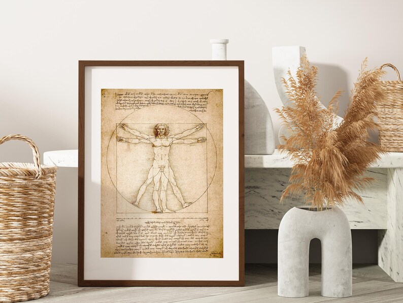 May include: A framed print of Leonardo da Vinci's Vitruvian Man, featuring a male figure within a circle and square, with detailed anatomical drawings and handwritten text. The artwork is displayed in a brown frame with a white mat.