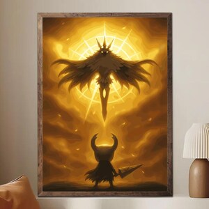 May include: A framed art print featuring a stylized, golden-hued illustration. The artwork depicts a silhouetted figure with a crown and outstretched wings above a smaller figure holding a spear. The background has a radiant, sun-like design.