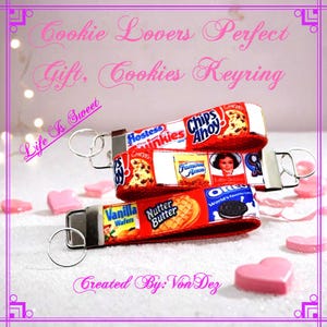 May include: A red and white keychain with a variety of cookie brand logos, including Chips Ahoy, Nutter Butter, and Oreo. The keychain has a silver key ring and the text "Life is Sweet" and "Created By: Von Dez".